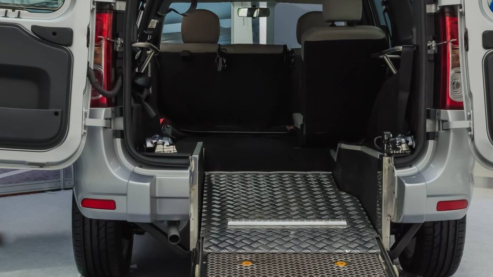 Pickup van A silver suv with a wheelchair ramp in the back.