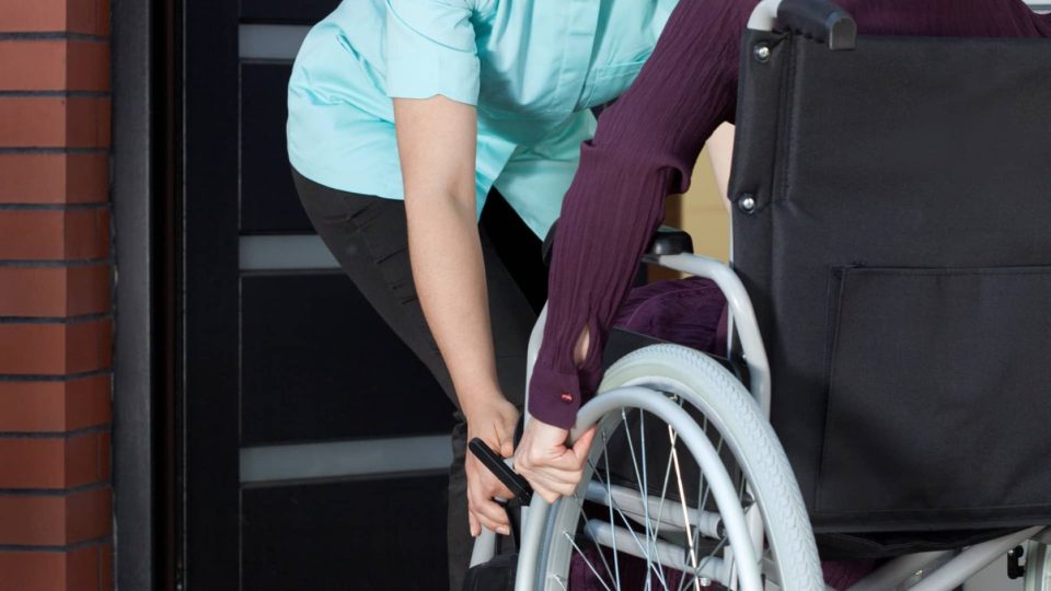 Wheelchair A nurse helping a woman in a wheelchair.