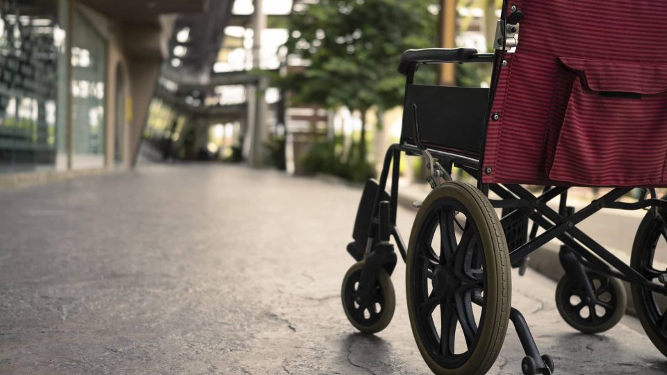 A wheelchair sitting on a sidewalk in front of a building.